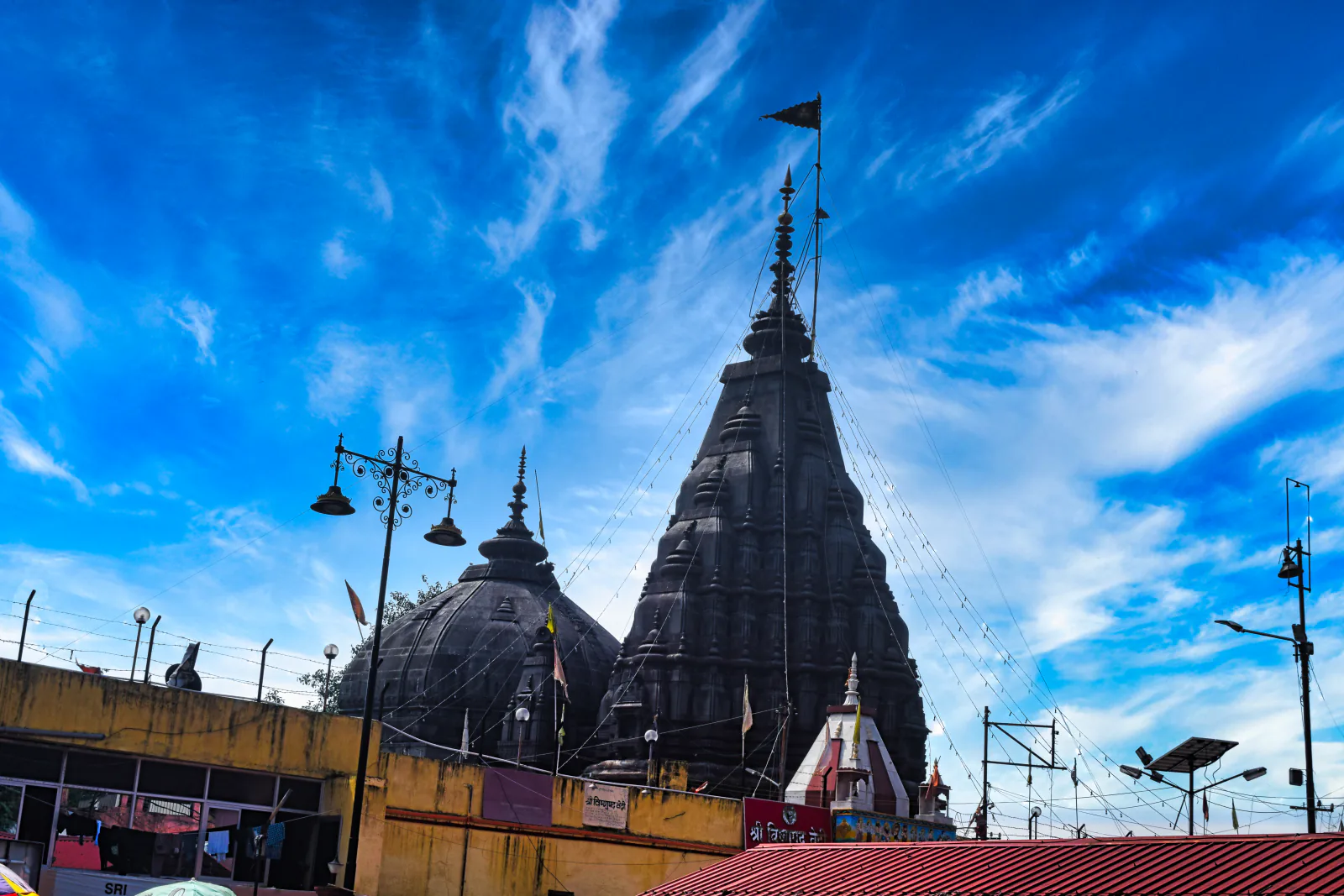 Stone spire and domes of Vishnupad Temple beneath a blue sky in Gaya