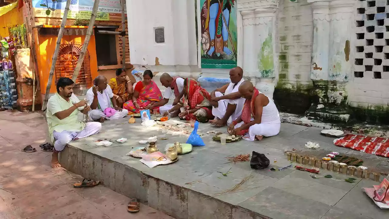 Picture of a family seeting on the flore of temple on the day of Pitrupaksha Navami Tithi and they do rituals of there ancester's.