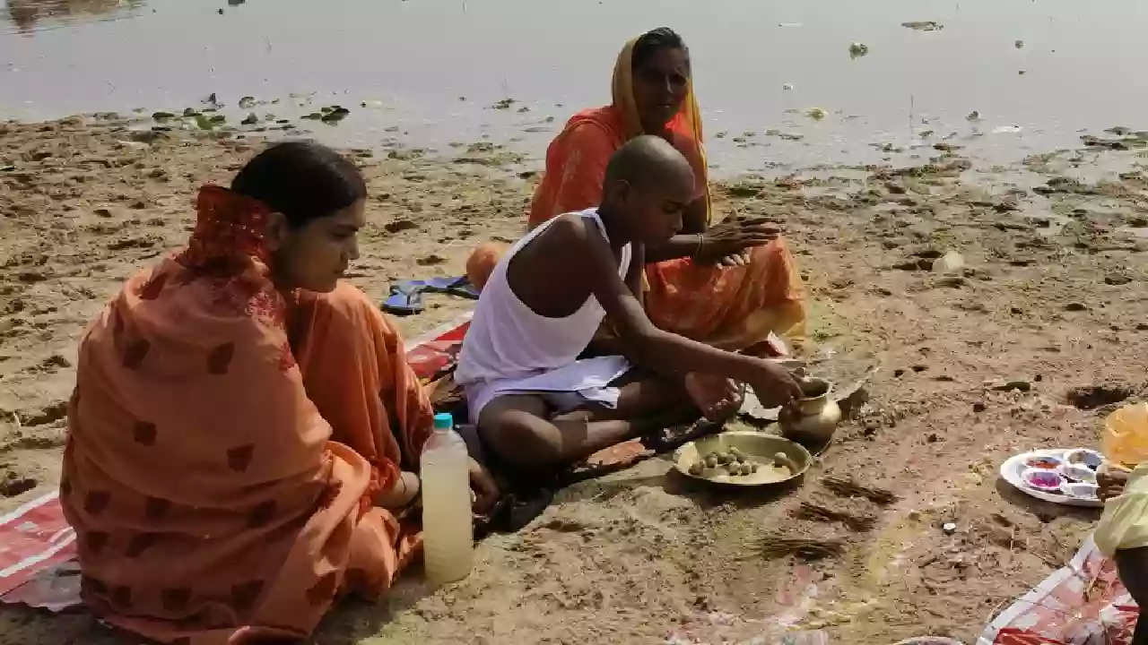Photo of a small kid performing pind daan for his father. Pitrupaksha and Self-Discovery