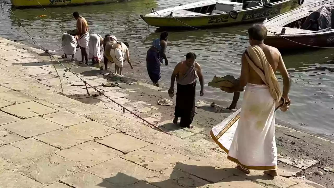 Image of some people doing tarpan near the ghats-What is Pitrupaksha