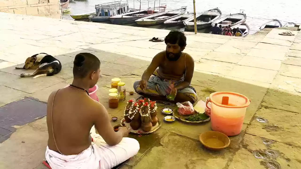 picture of a person seting near the ghat and performing the ritual for there ansester's on the time of Dwadashi Tithi.