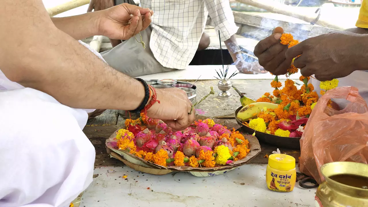 Image of a person doing shradh rituals for their ancestors offer flower petels on floor- Emotional benefits of Shradh