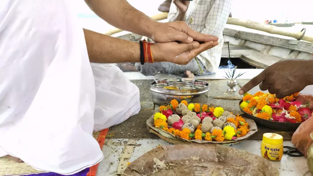 Image of performing Tarpan or offering during Shraddh with pindas, flowers, and ritual items- Karna 15 days boon Pitrupaksha