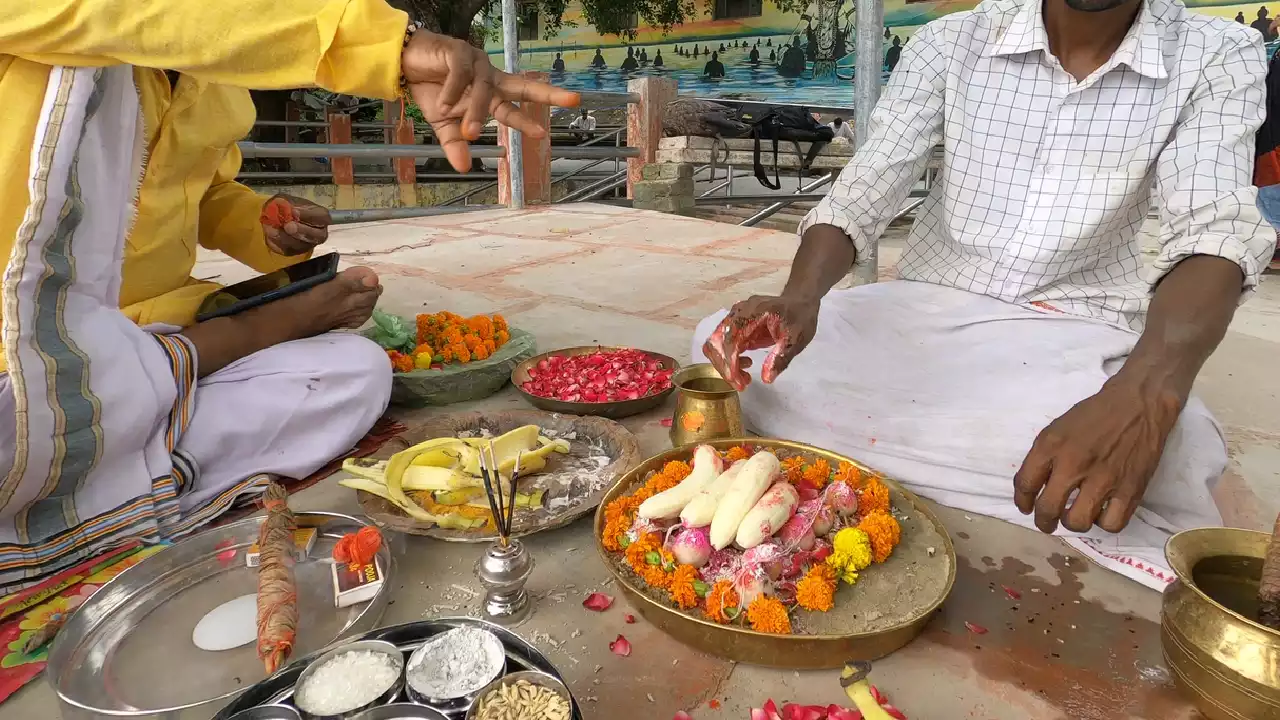 Two men perform a Pind daan ritual, offering pindas, flowers, bananas, and incense to ancestors- Pind Daan vs Tarpan difference