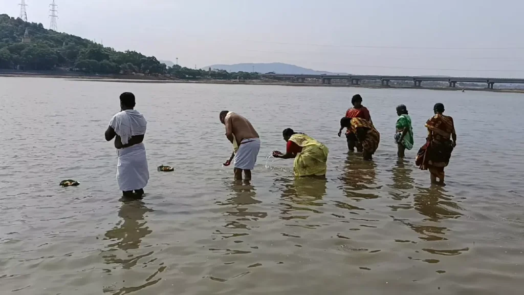 Devotees performing Tarpan in a holy river for ancestors- Home Shradh Materials Checklist